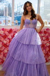 Woman in a purple gown standing in front of a floral wall